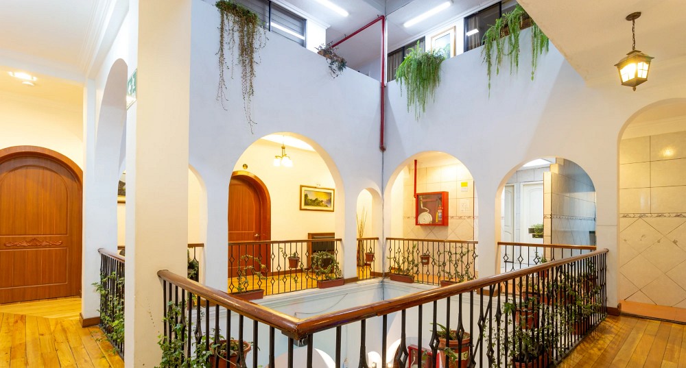 Balcones con barandas de hierro y plantas alrededor del patio