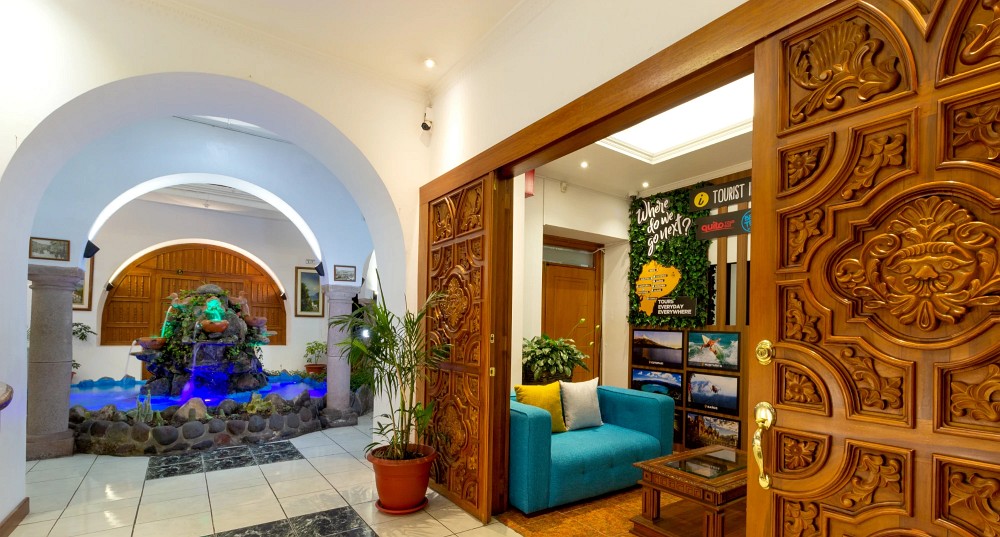 Entrada del hotel con puertas de madera tallada y vista al patio