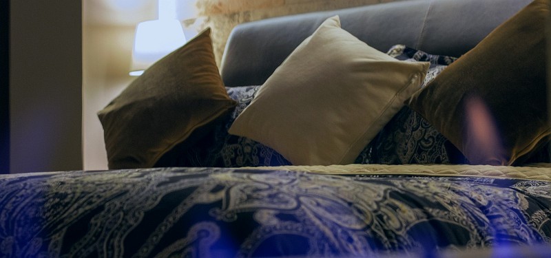 Detalle de los cojines de terciopelo sobre la cama