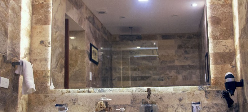 Baño de mármol con doble lavabo y espejo iluminado