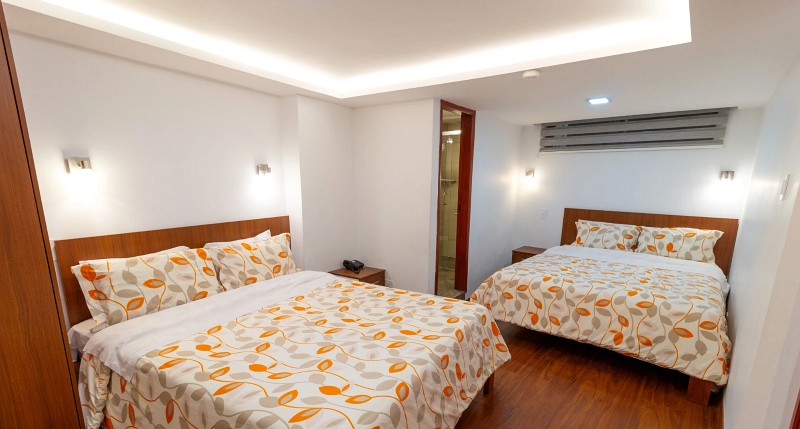 Habitación con dos camas, techo iluminado y baño privado