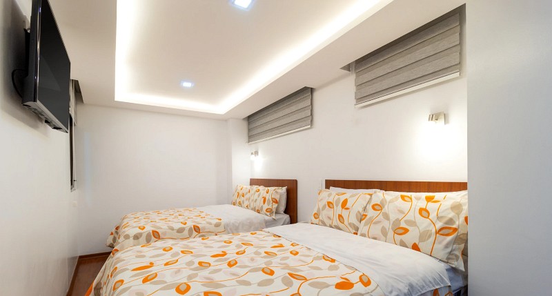 Habitación con dos camas, televisión y persianas