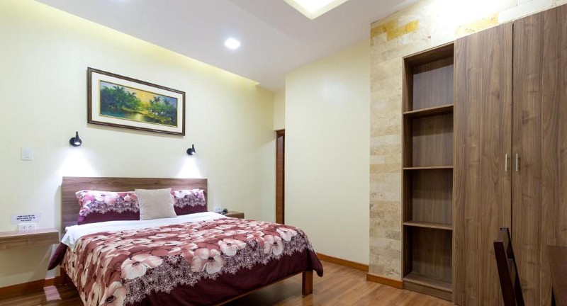 Suite Junior con cama grande, armario, pared de piedra y piso de madera