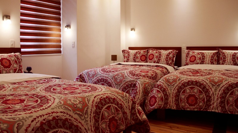 Tres camas con colchas de mandala rojas