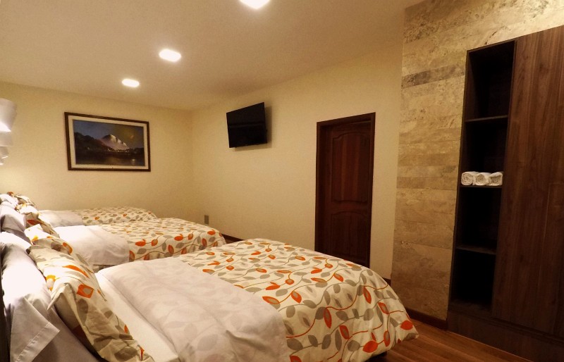 Armario y pared de piedra junto a las camas