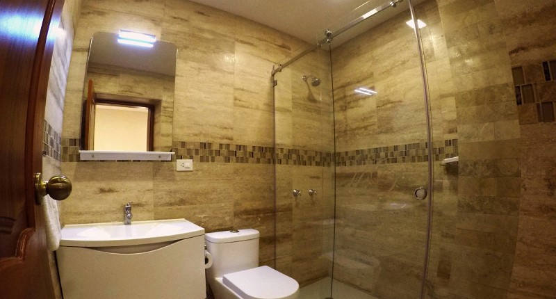 Baño privado de mármol con ducha de vidrio